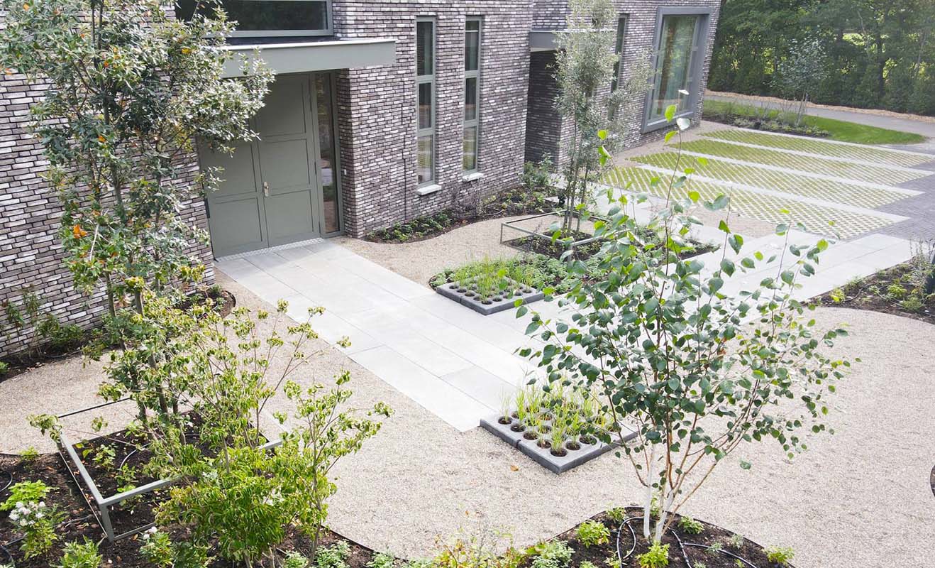 Openbaar groen bij crematorium Wolfswinkel met bomen, heesters en plantvakken langs de bestrating