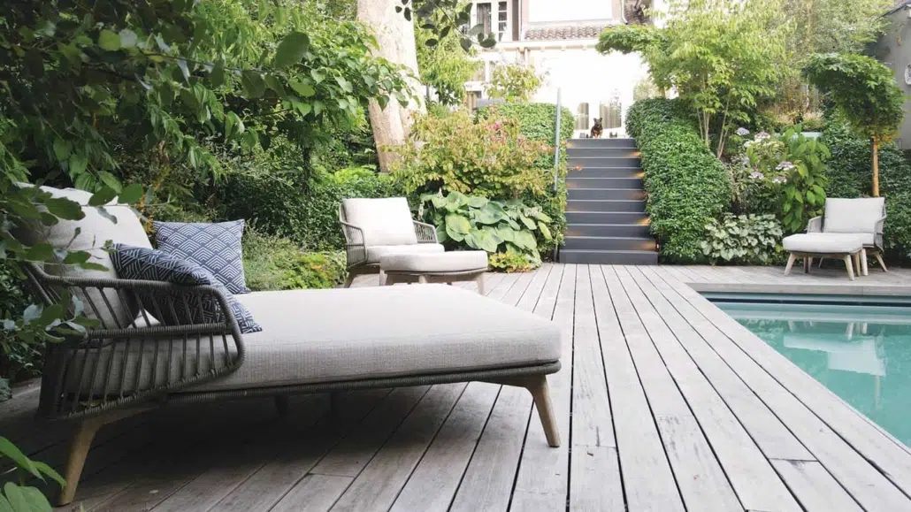 Houten vlonder met ligbed naast het zwembad in een luxe wellnesstuin in Den Bosch
