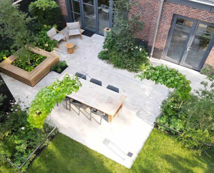 Sfeervolle tuin in Vught met terras, eettafel en verhoogde plantenbakken, van bovenaf gezien