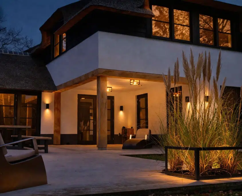 Sfeervol verlichte tuin en terras bij een villa in de avond